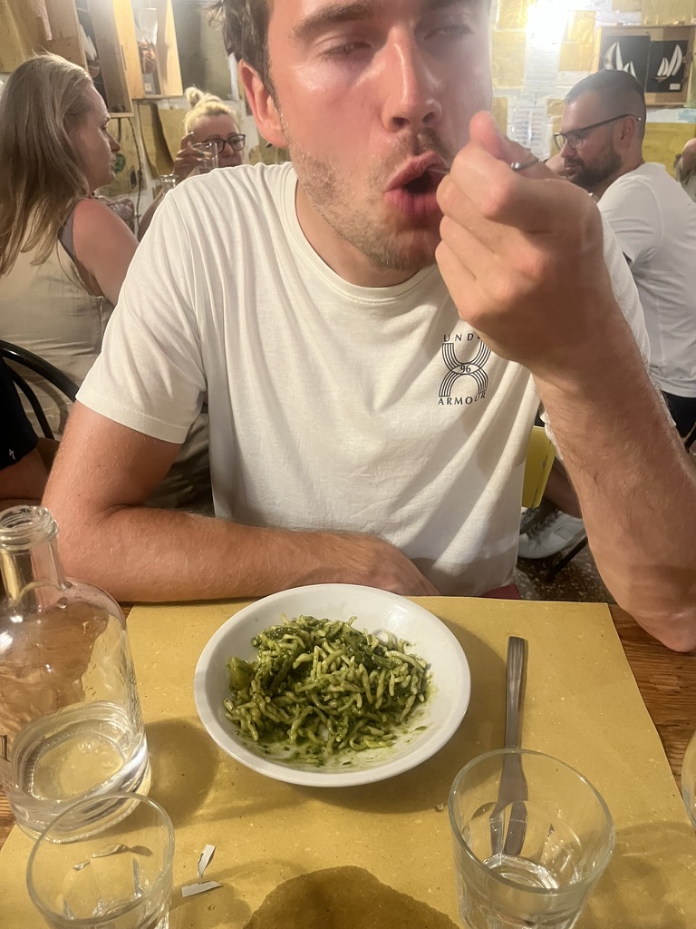 Man enthusiastically tasting pesto pasta